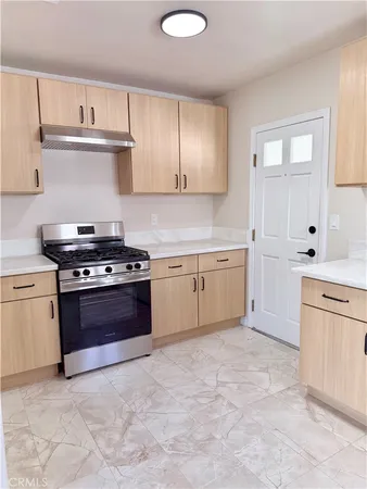 a kitchen with stainless steel appliances granite countertop a stove a sink and a refrigerator