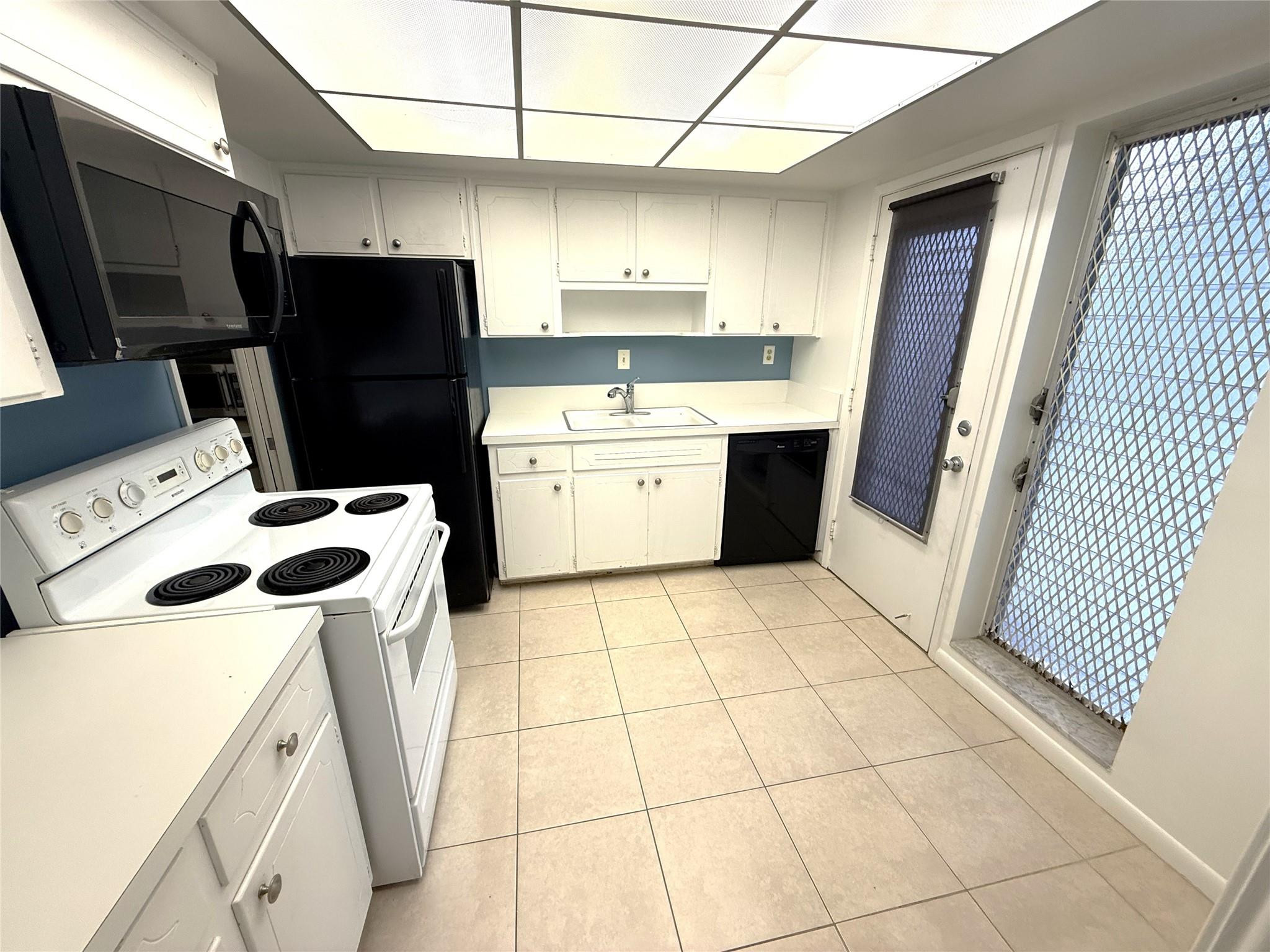 3205 Colony Club Road, Unit 1 Pompano Beach, FL 33062 - Photo 3 of 12 a kitchen with a refrigerator a stove top oven a sink and dishwasher