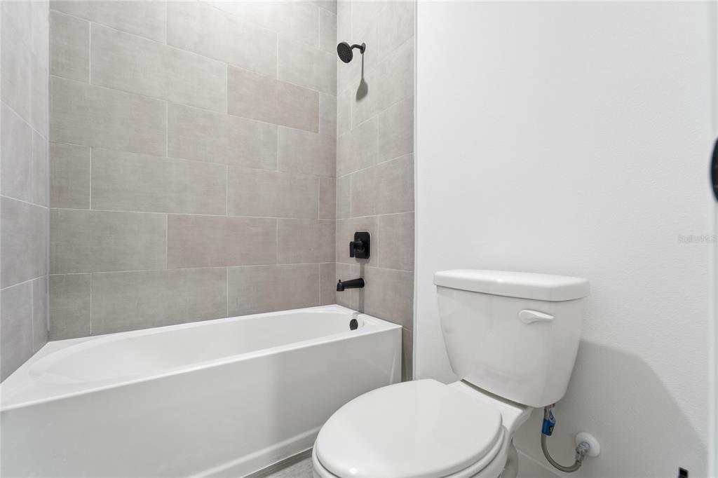 2600 Southwest 146th Pl Road Ocala, FL 34473 - Photo 18 of 40 a white toilet and tub sitting next to a bathroom sink