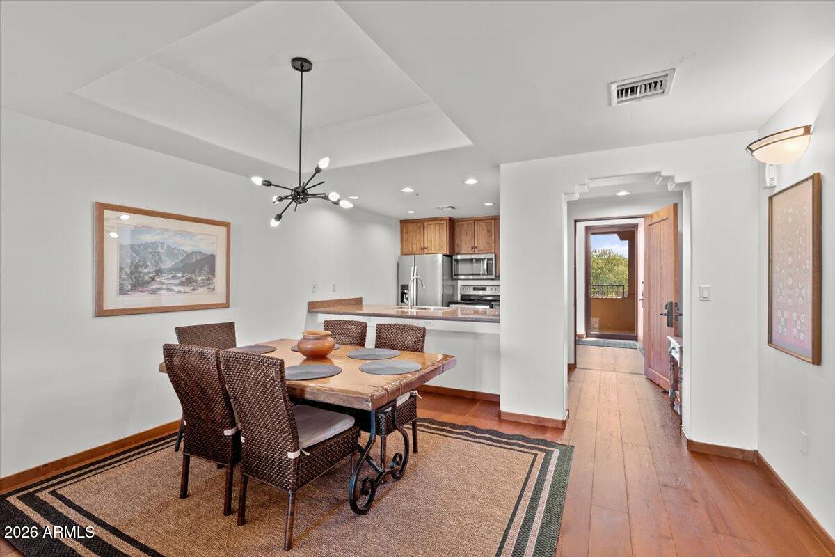 36601 North Mule Train Road, Unit C16 Carefree, AZ 85377 - Photo 17 of 38 a dining room with furniture a rug a chandelier and wooden floor