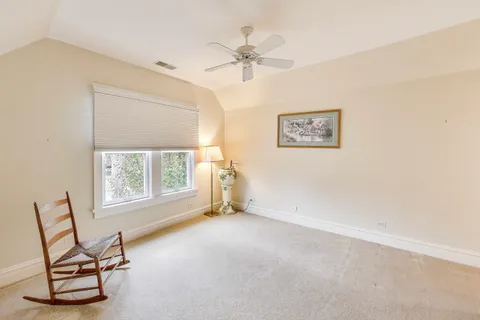 an empty room with windows and ceiling fan
