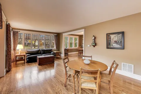 a dining room with wooden floor and furniture