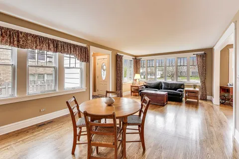 a dining room with furniture window and wooden floor
