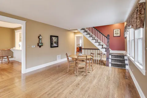 a view of a livingroom with wooden floor and stairs