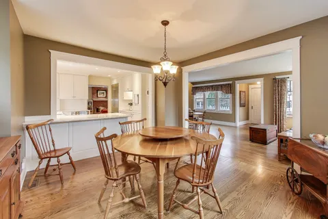 a dining room with furniture a chandelier and wooden floor
