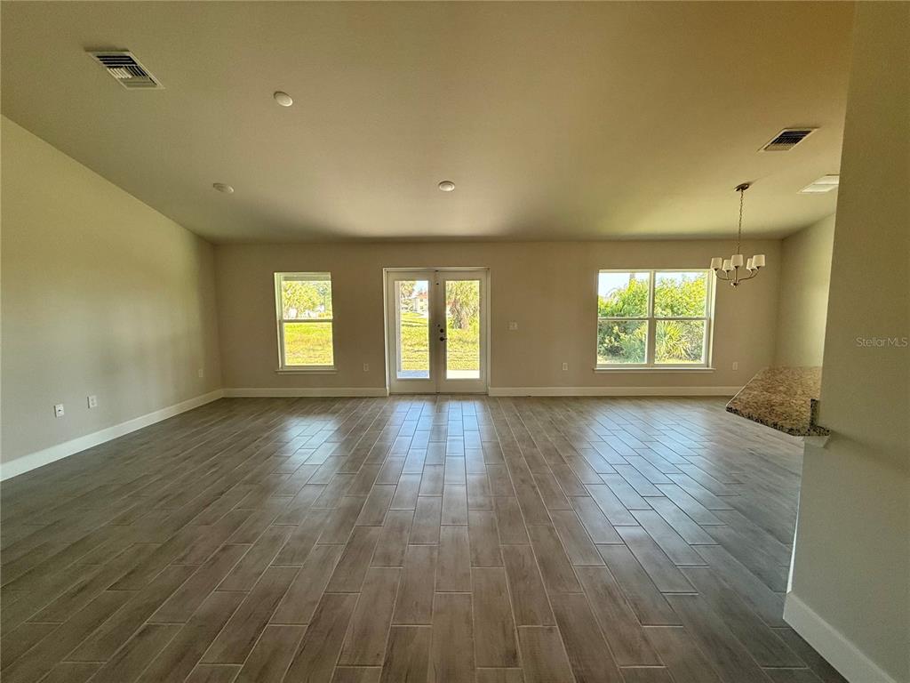 135 Hardee Way Rotonda West, FL 33947 - Photo 12 of 30 an empty room with wooden floor and windows