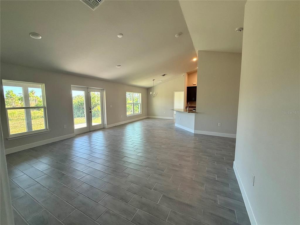 135 Hardee Way Rotonda West, FL 33947 - Photo 14 of 30 an empty room with wooden floor and windows