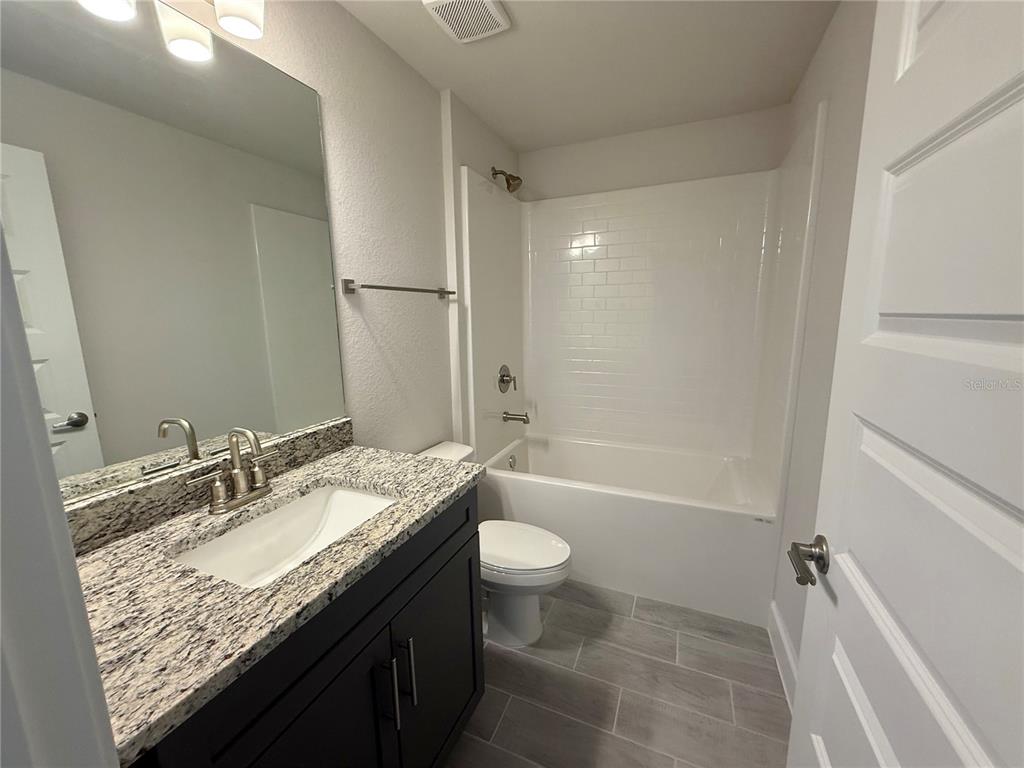 135 Hardee Way Rotonda West, FL 33947 - Photo 16 of 30 a bathroom with a granite countertop sink toilet and shower