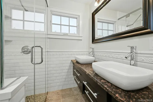a bathroom with a granite countertop a sink a toilet and shower
