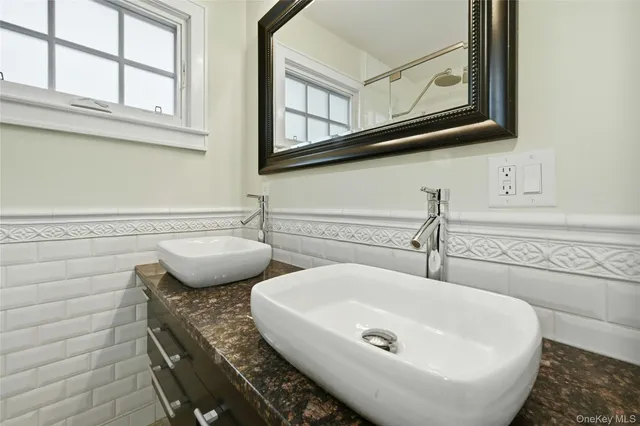 a bathroom with 2 sink and a mirror