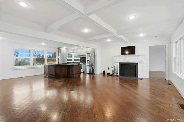 an empty room with wooden floor and fireplace