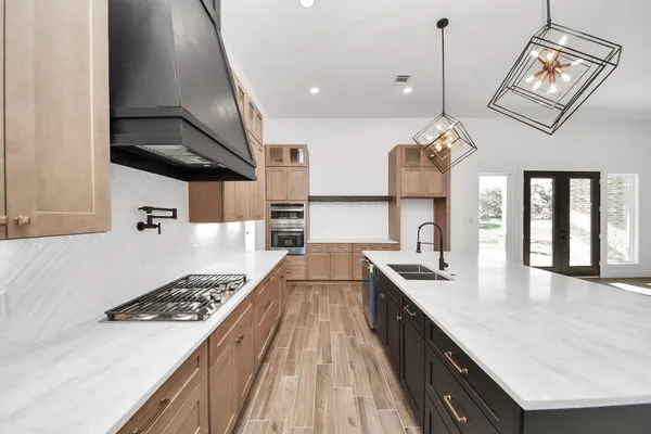 a large kitchen with a sink and a stove top oven