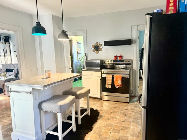 a kitchen with stainless steel appliances granite countertop a stove a refrigerator and a wooden floor