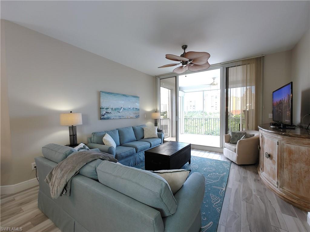 400 Flagship Drive, Unit 501 Naples, FL 34108 - Photo 14 of 38 a living room with furniture a flat screen tv and a large window