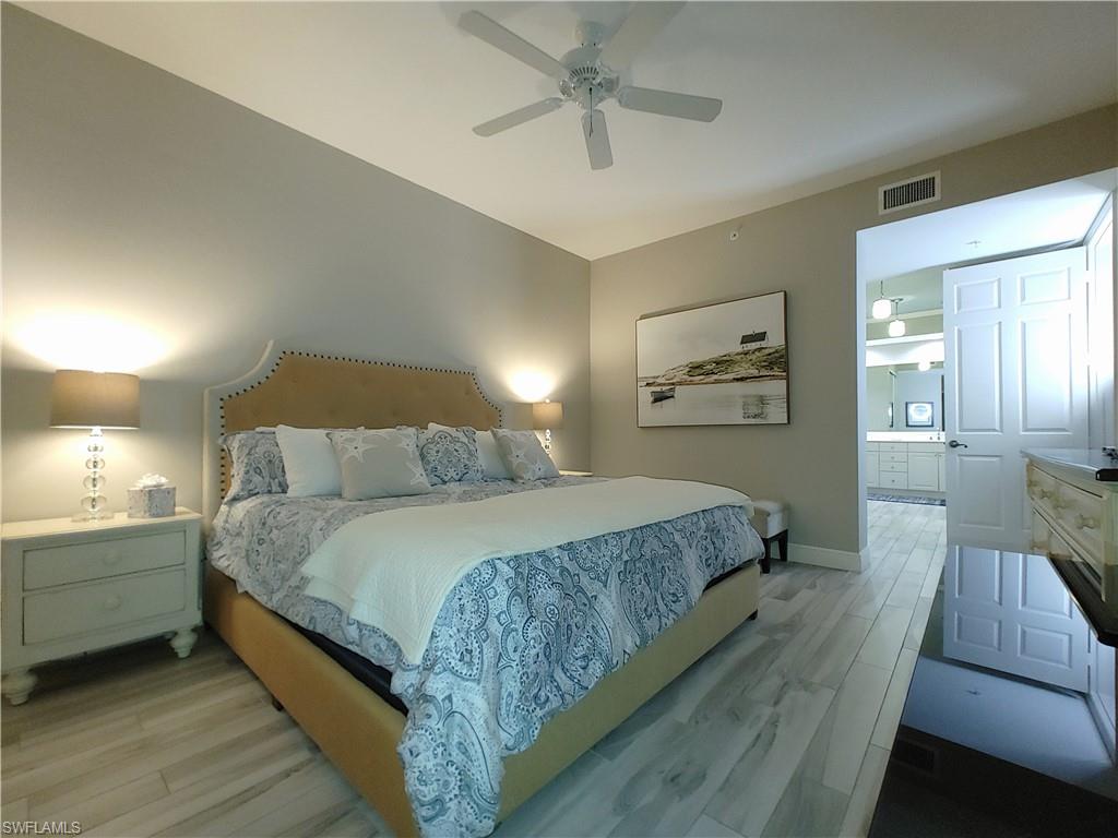 400 Flagship Drive, Unit 501 Naples, FL 34108 - Photo 18 of 38 a bedroom with a bed and a chandelier
