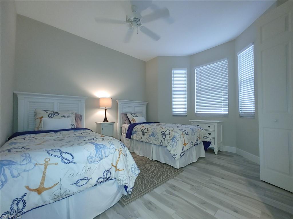 400 Flagship Drive, Unit 501 Naples, FL 34108 - Photo 23 of 38 a bedroom with two beds and wooden floor