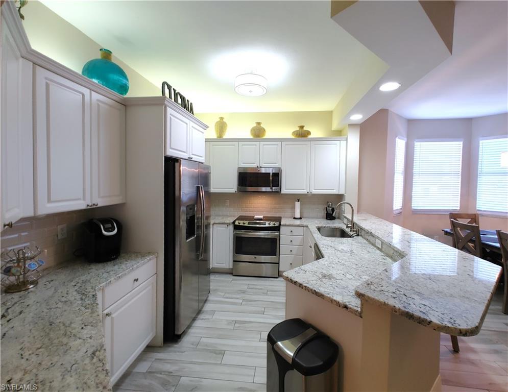 400 Flagship Drive, Unit 501 Naples, FL 34108 - Photo 8 of 38 a kitchen with a sink stove and refrigerator