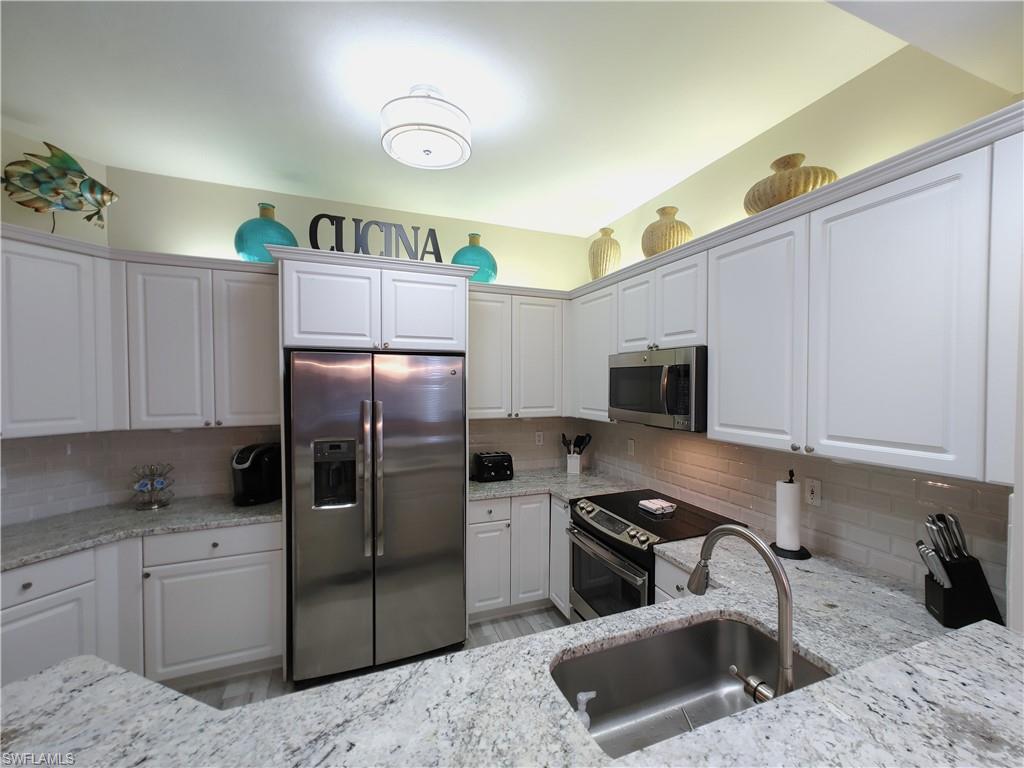400 Flagship Drive, Unit 501 Naples, FL 34108 - Photo 10 of 38 a kitchen with stainless steel appliances granite countertop a refrigerator sink and stove