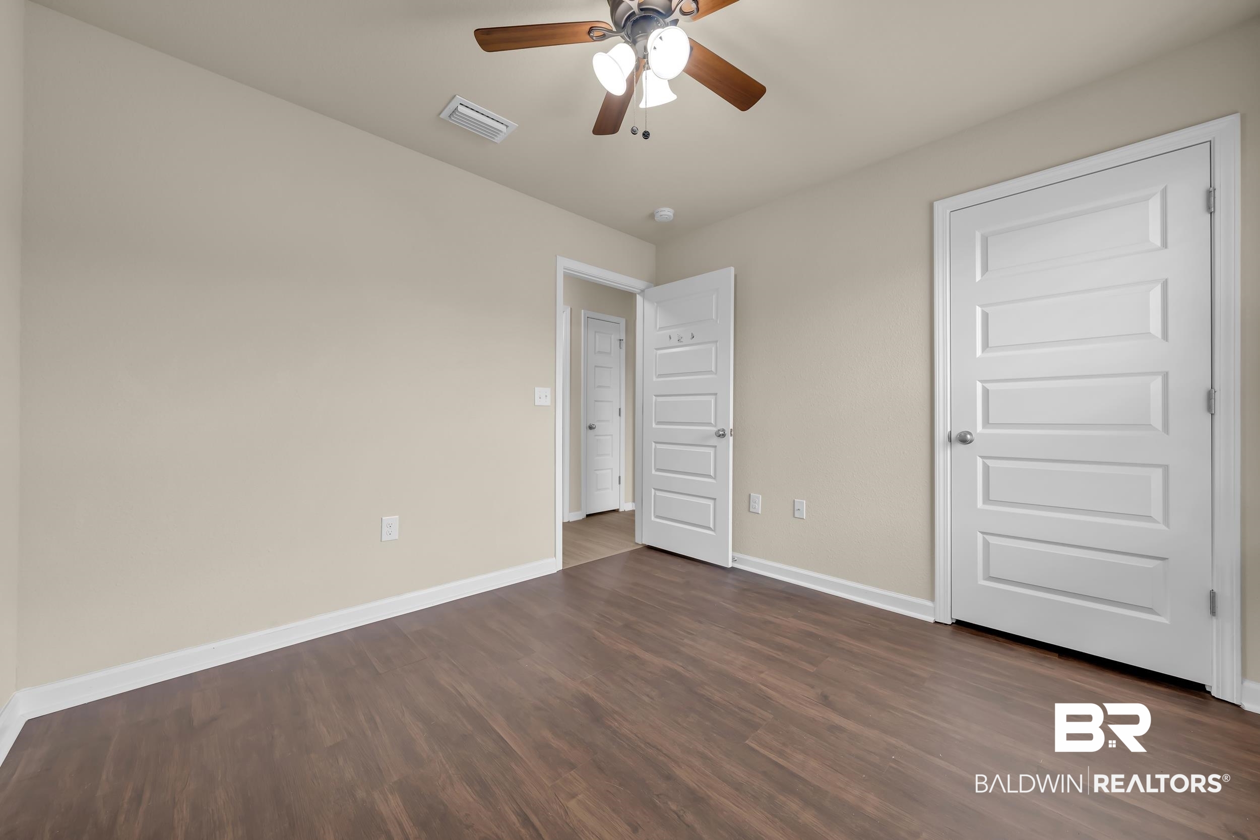 1704 Abbey Loop Foley, AL 36535 - Photo 23 of 38 Neutral-toned interior featuring wood-finish flooring, white baseboards, and a ceiling fan with integrated lighting