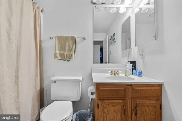 a bathroom with a sink vanity mirror and toilet