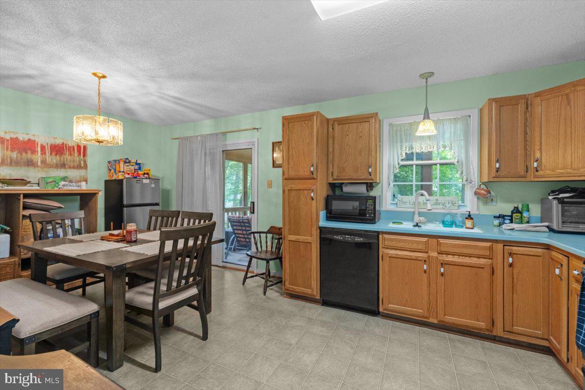 115 Indian Hills Road Locust Grove, VA 22508 - Photo 7 of 20 a kitchen with a table chairs refrigerator and cabinets
