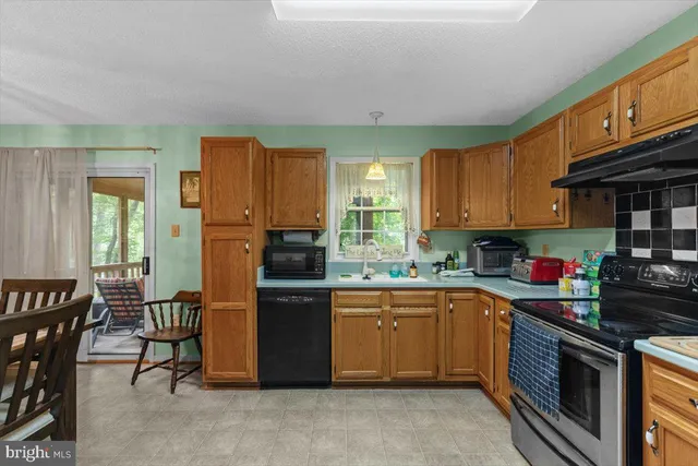 a kitchen with stainless steel appliances granite countertop a stove top oven a sink dishwasher and cabinets with wooden floor