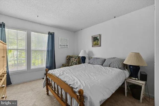 a bedroom with a bed a table and a window