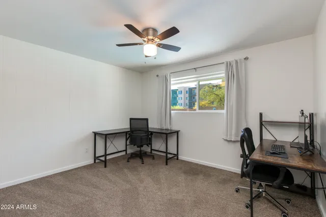 a view of a workspace with furniture and a window