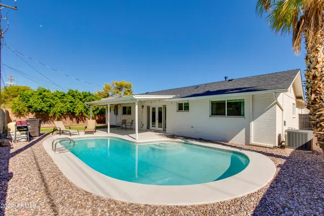 a view of an house with swimming pool and sitting area