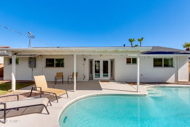 a view of a patio with table and chairs with wooden floor and fence