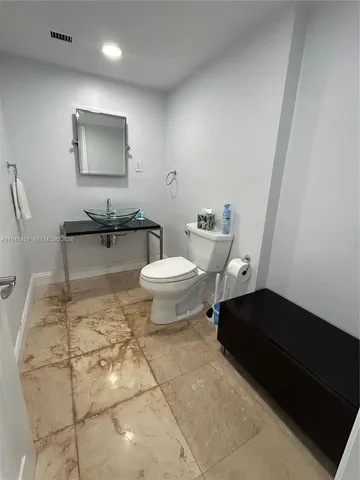 a bathroom with a toilet a sink and mirror