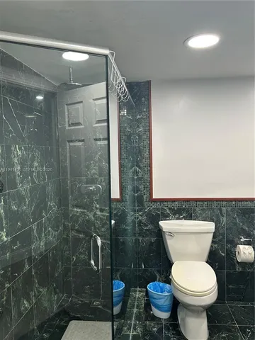 a bathroom with a toilet and a shower