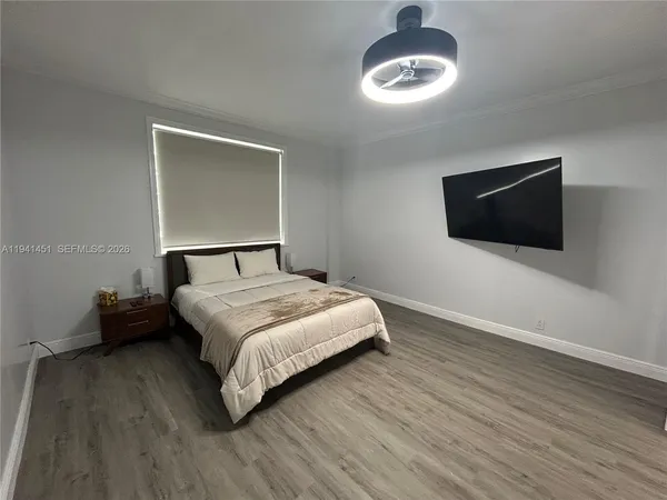a bedroom with a bed and a flat screen tv