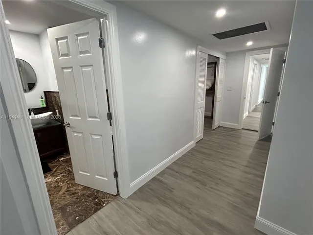 a view of a hallway with wooden floor and entryway