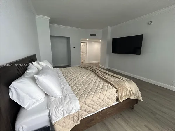a bedroom with a bed and a flat screen tv