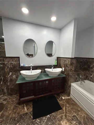 a bathroom with a double vanity sink and a mirror