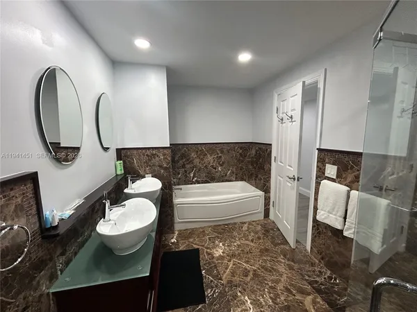 a bathroom with a bathtub sink and a mirror