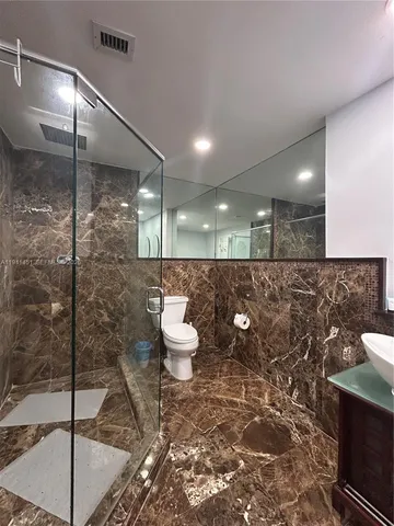 a bathroom with a toilet a sink and a shower