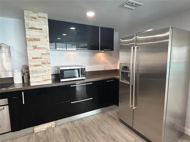 a modern kitchen with a refrigerator and a sink