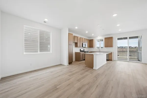 a view of kitchen with granite countertop cabinets and refrigerator