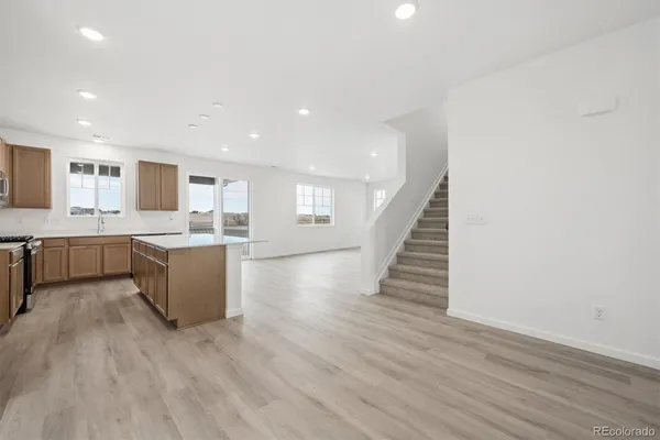 a large kitchen with wooden floors and stainless steel appliances