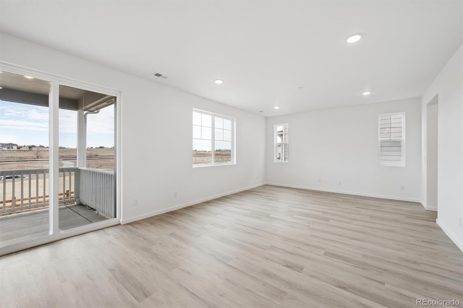 424 South Rifle Street Aurora, CO 80017 - Photo 8 of 23 an empty room with wooden floor and windows