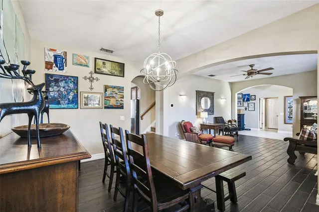 a kitchen with stainless steel appliances kitchen island granite countertop a refrigerator a sink a stove and wooden cabinets