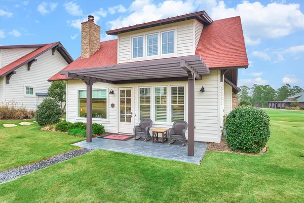 a view of a house with a backyard and sitting area