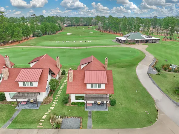 an aerial view of a house with outdoor space and trees all around