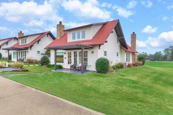 a view of a house with a yard and sitting area