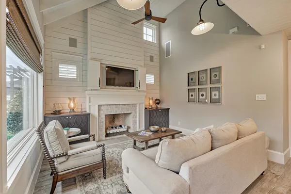 a living room with furniture a fireplace and a flat screen tv