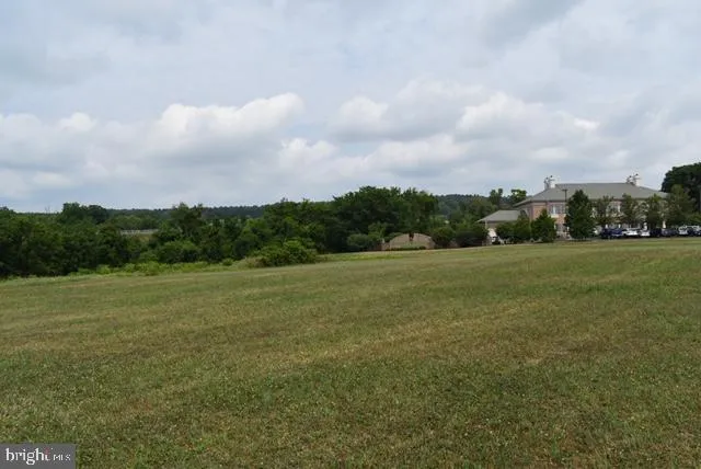 a view of a green field with wooden fence