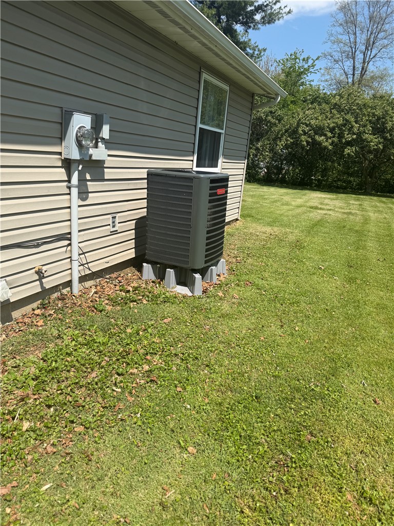5840 Pitchin Road South Springfield, OH 45502 - Photo 15 of 18 This exterior view showcases the home's essential mechanical systems and the surrounding outdoor space.
