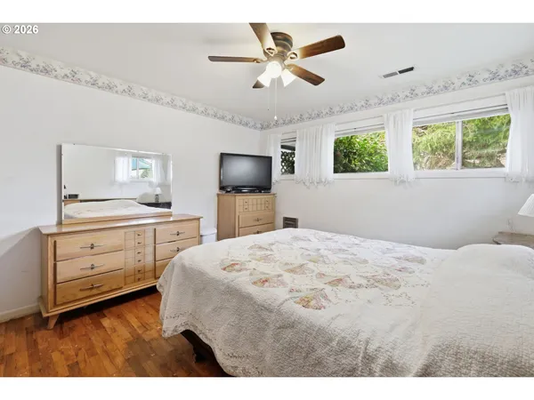 a bedroom with a bed dresser and a window